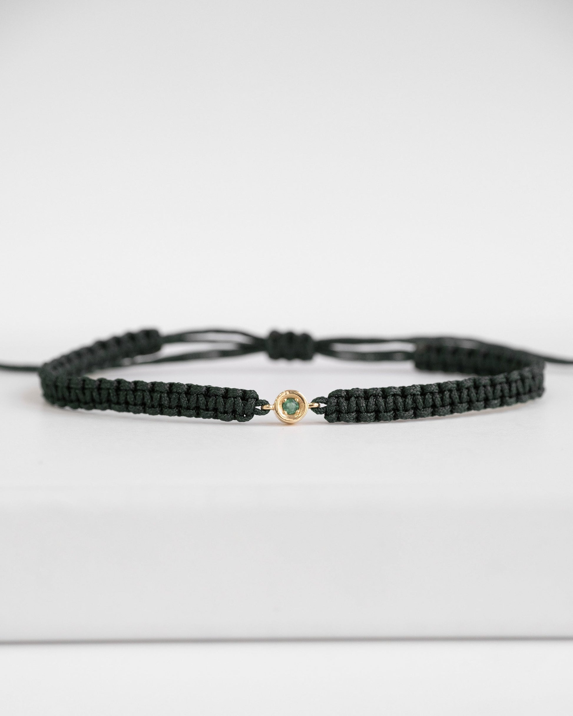 green cord bracelet with gold clasp and emerald stone 
