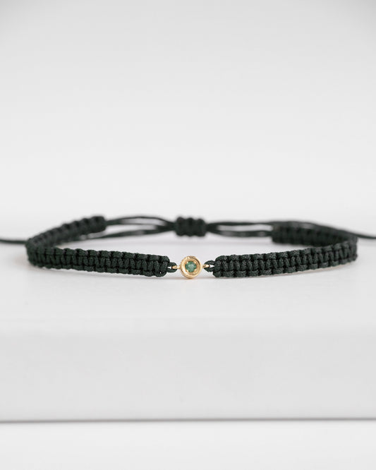 green cord bracelet with gold clasp and emerald stone