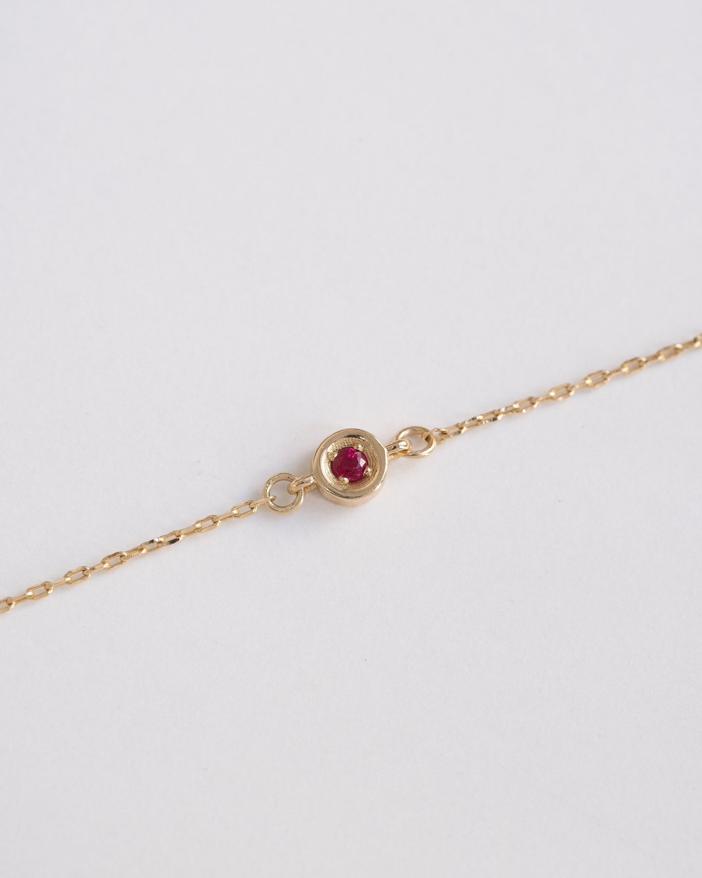 delicate gold chain bracelet with single ruby stone 