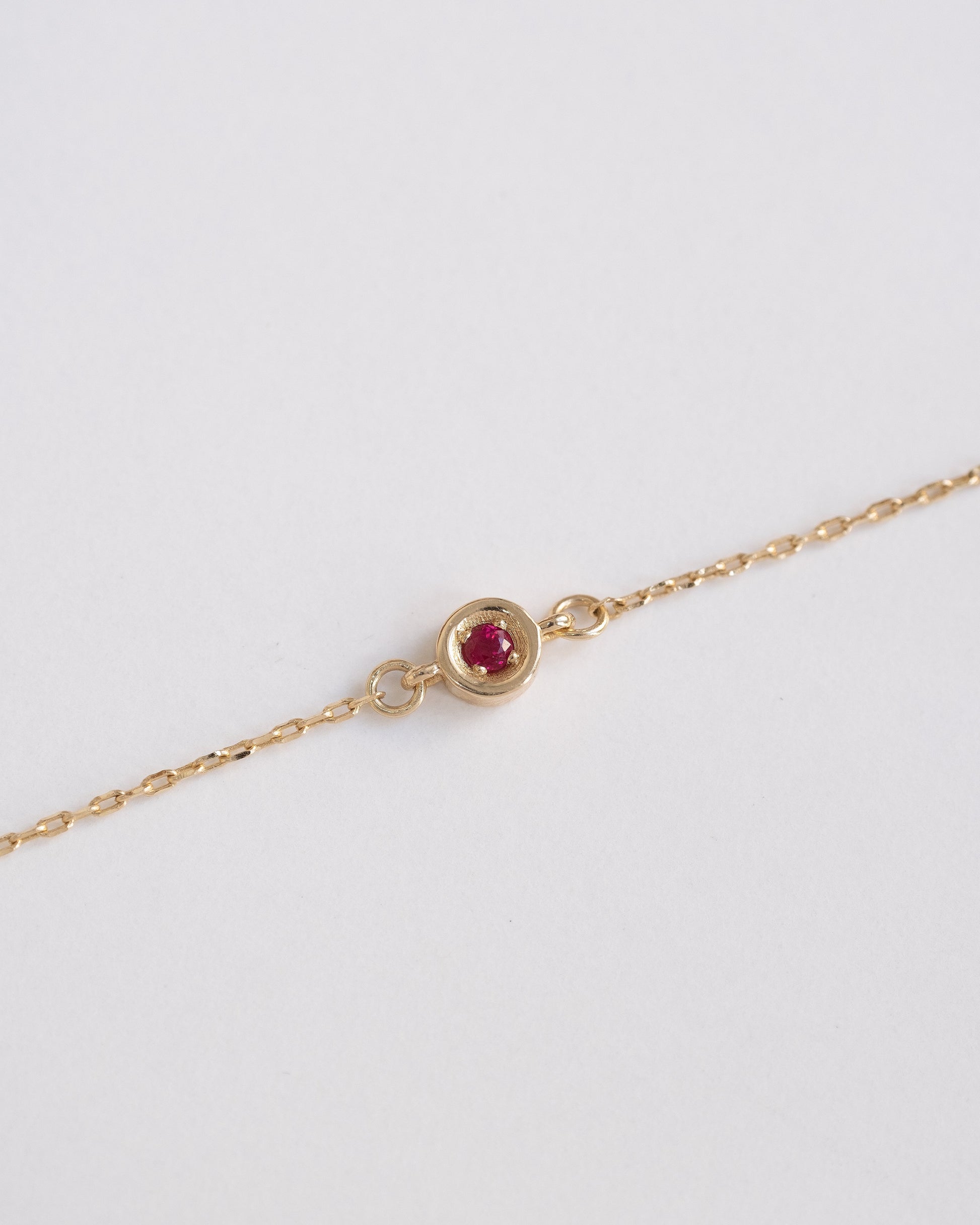 delicate gold chain bracelet with single ruby stone 