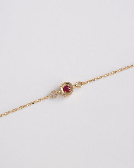 delicate gold chain bracelet with single ruby stone