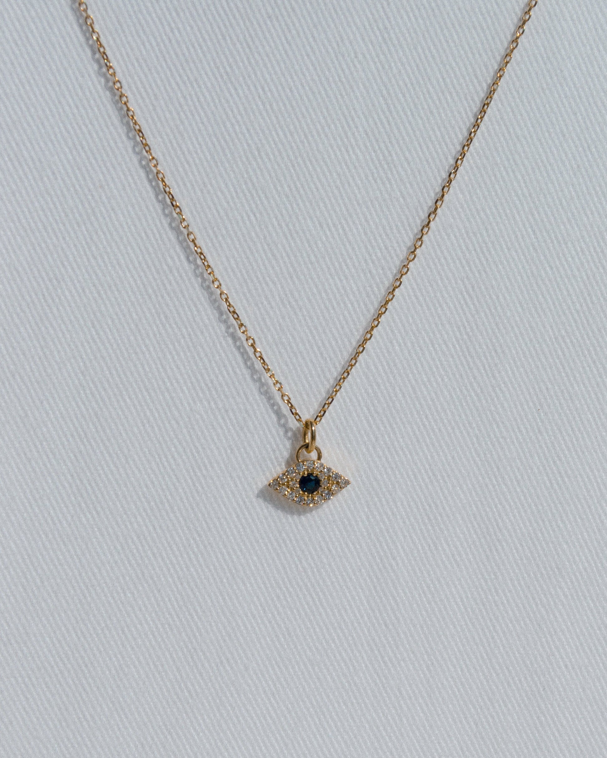 delicate gold chain necklace with evel eye pendant with blue sapphire and diamonds