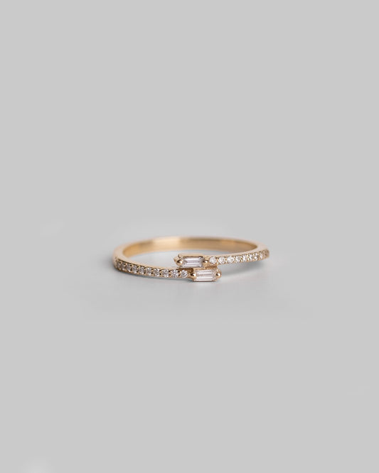 gold delicate ring with round diamond pave band and two crossover baguette diamonds 