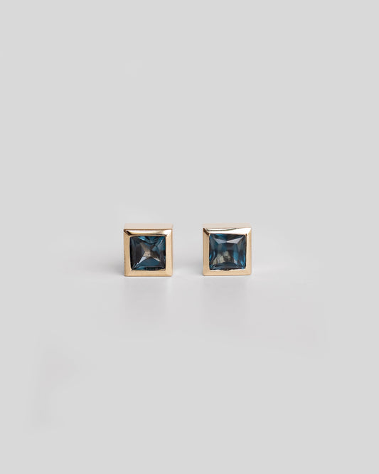 pair of gold square stud earrings with london blue topaz, deep blue gemstone gold earrings
