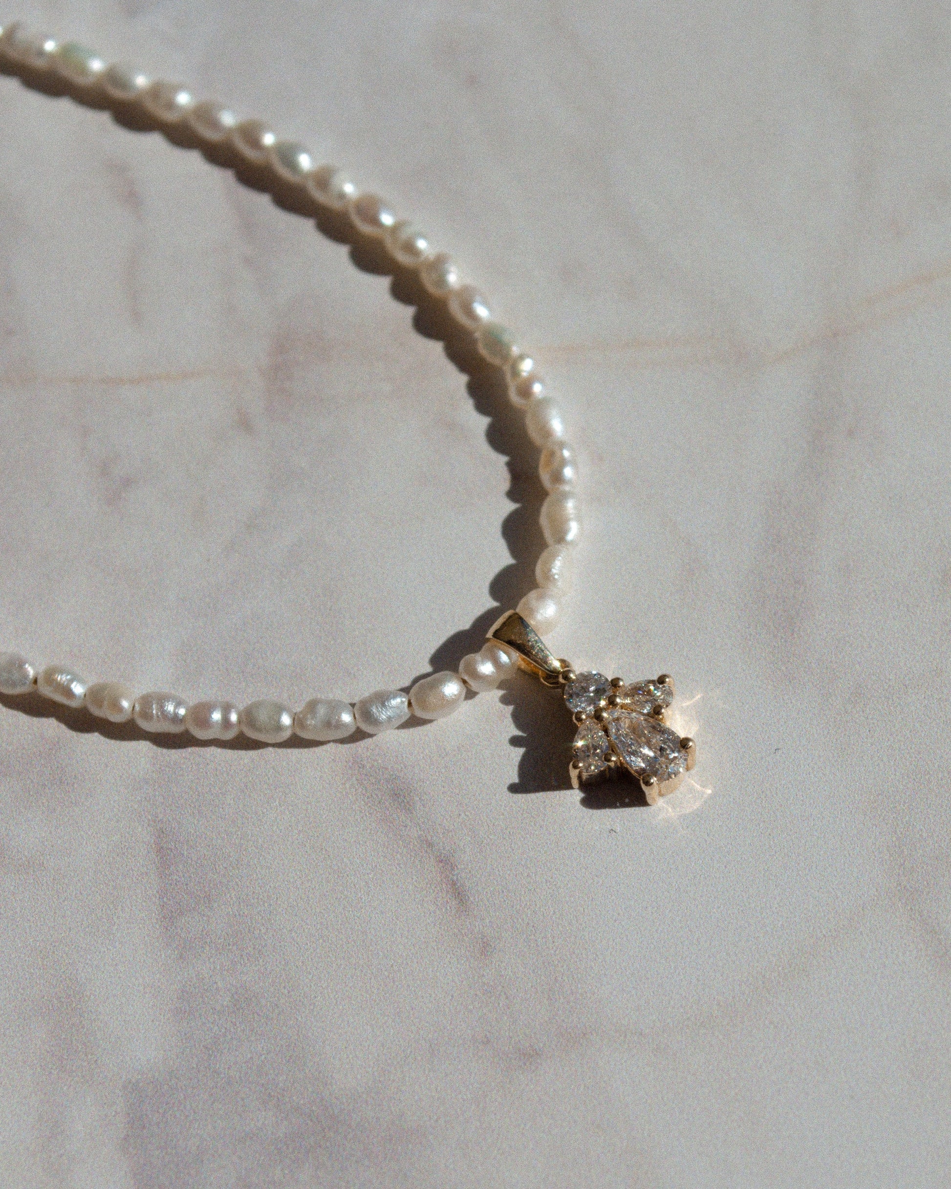 delicate beaded gold necklace with pearls and pear cut diamond pendant 