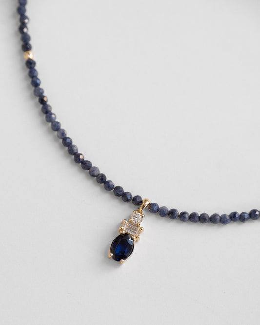 beaded gold necklace with blue sapphire, round and baguette diamond pendant