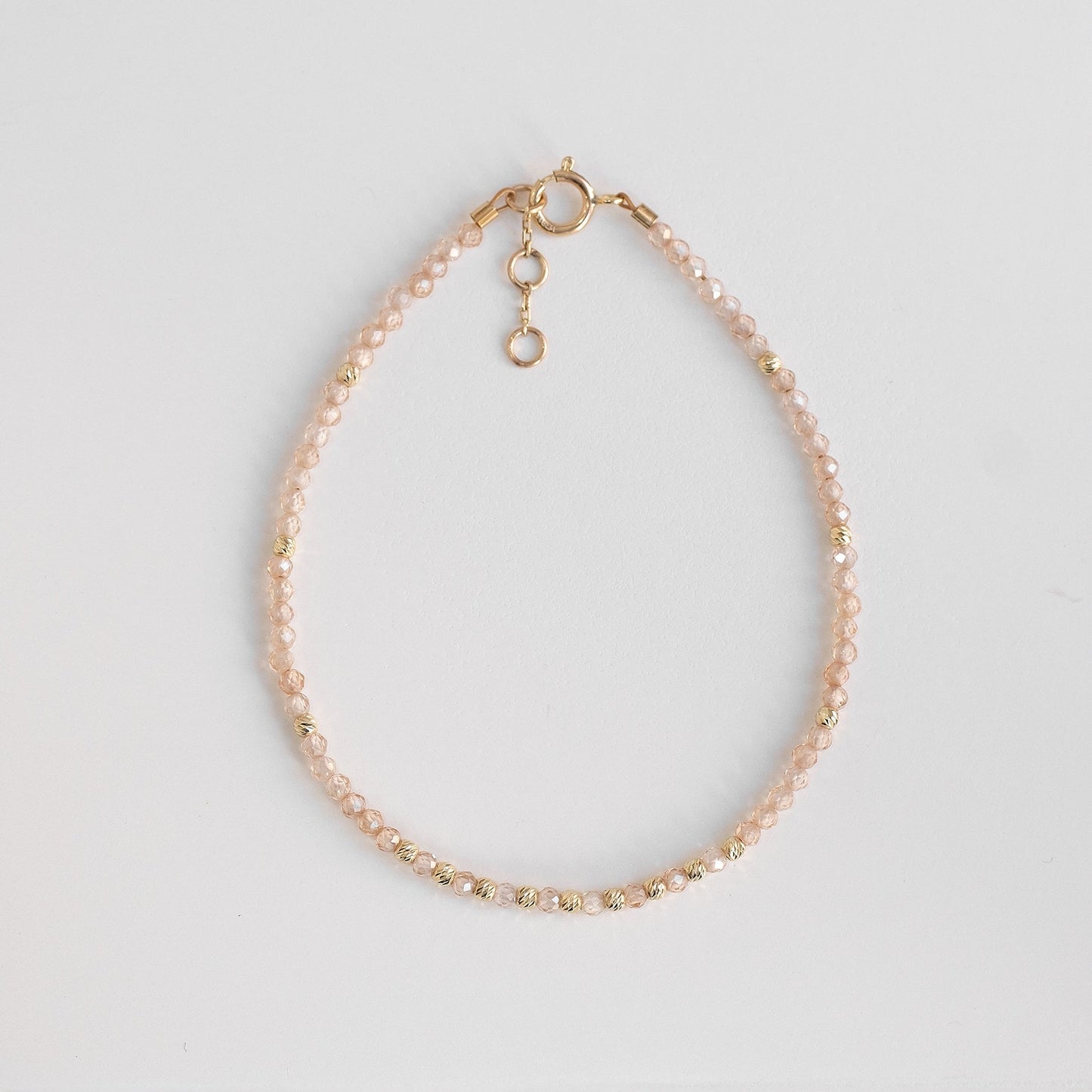 solid gold bracelet with delicate zirconia stones, beige beaded gold bracelet 